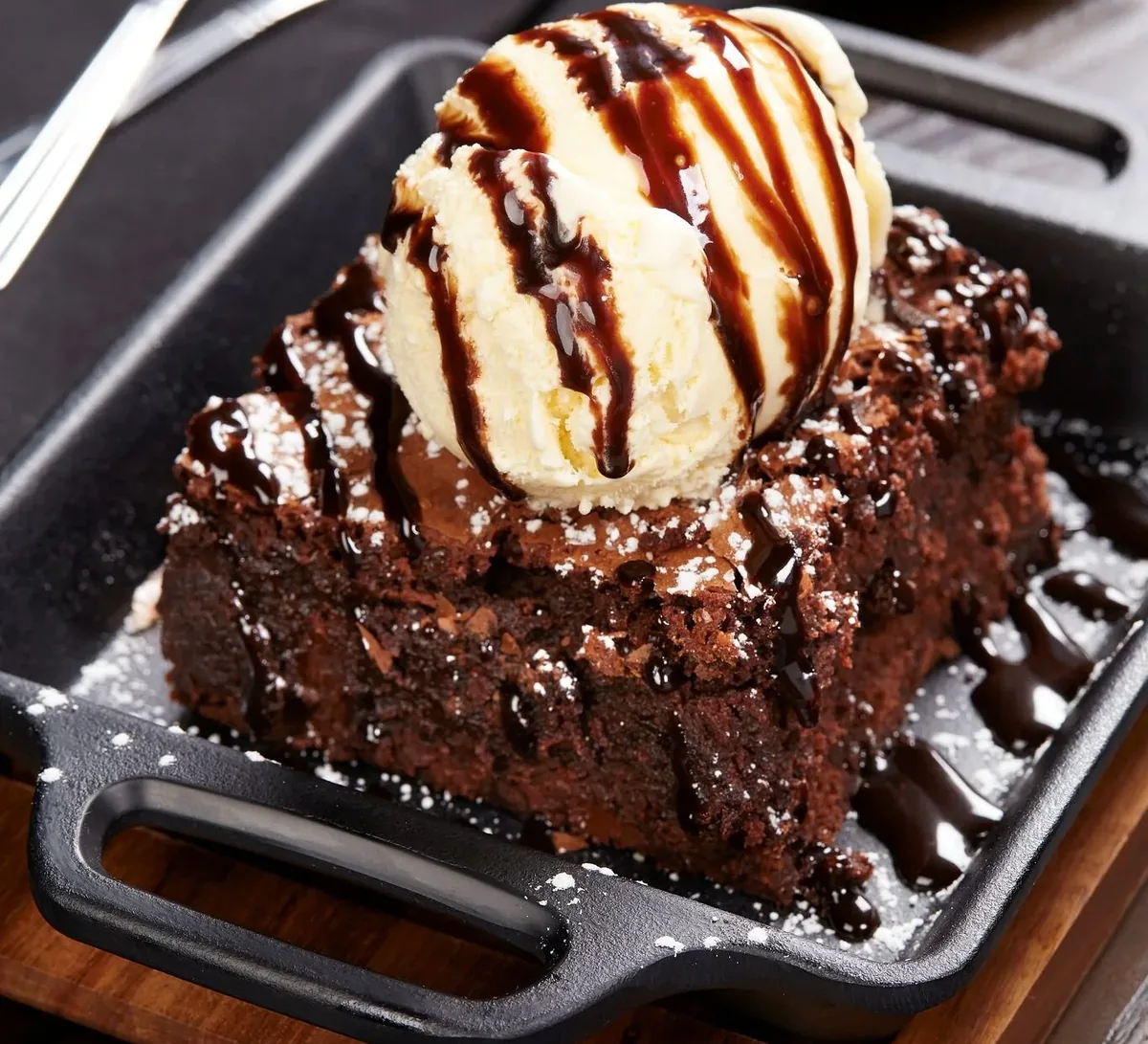 A hot fudge brownie with vanilla ice cream and chocolate sauce